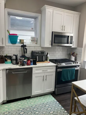 a kitchen with stainless steel appliances granite countertop a stove a sink and a microwave