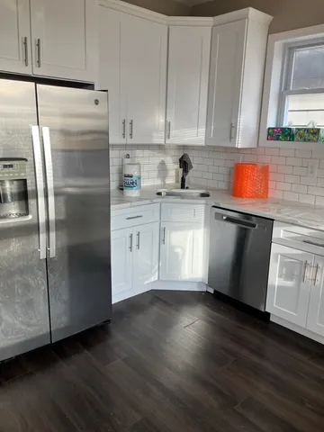 a kitchen with stainless steel appliances granite countertop a refrigerator a sink a stove and cabinets