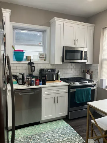 a kitchen with stainless steel appliances granite countertop a stove a sink dishwasher and a microwave