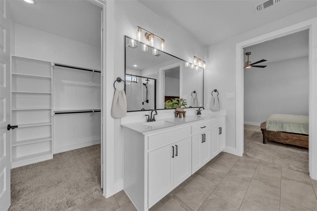 2004 Willy Dilly Road Springtown, TX 76082 - Photo 29 of 40 Dual vanity with integrated sinks, white cabinetry, and matte black hardware