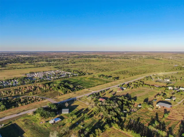 an aerial view of ocean and residential houses with outdoor space