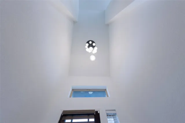 a view of an empty room with glass door and wooden floor