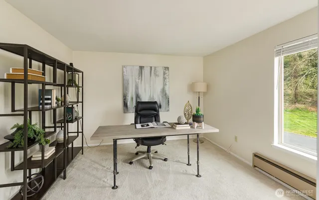 a view of a workspace with furniture and a window