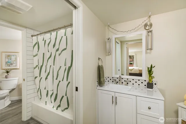 a bathroom with a sink a toilet and a mirror