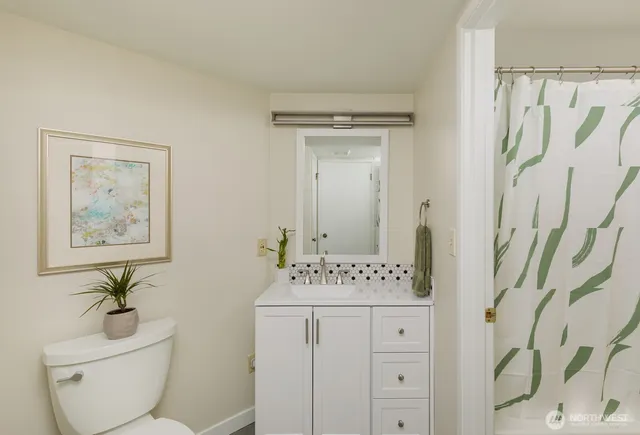 a view of bathroom with a toilet sink and mirror