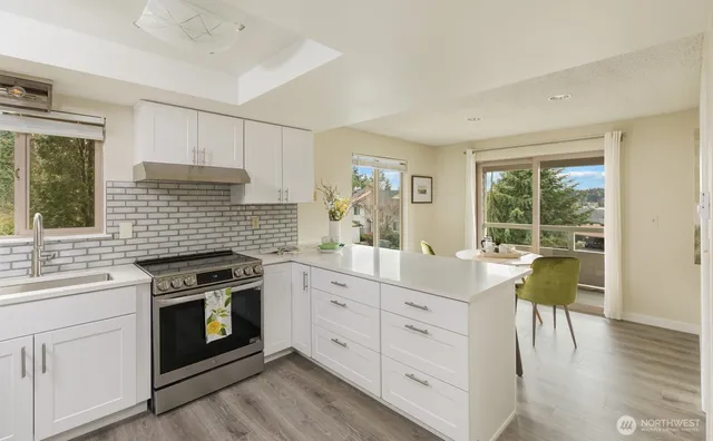 a kitchen with a stove a sink and wooden floor