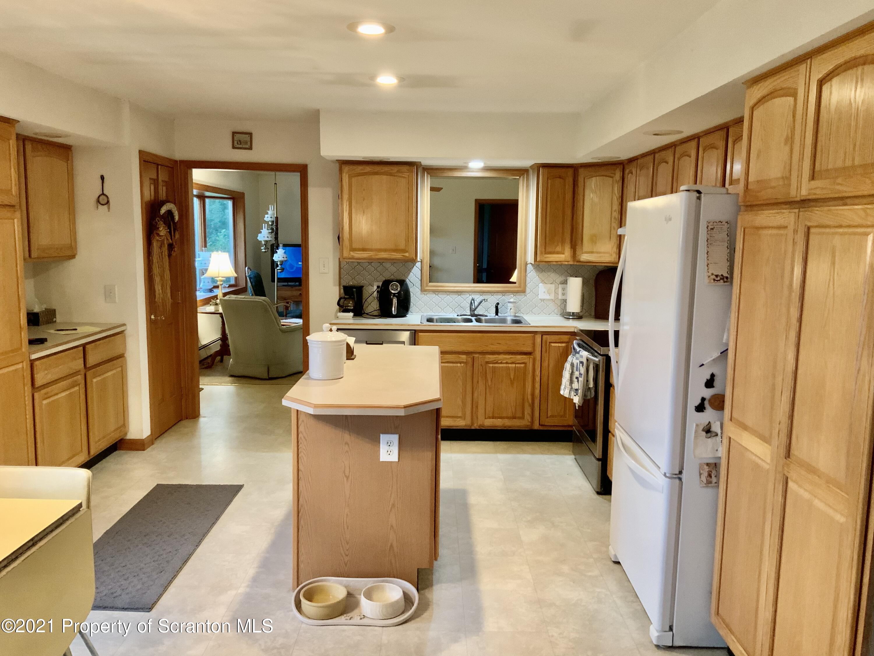 647 Bennett Road Meshoppen, PA 18630 - Photo 13 of 35 a kitchen with stainless steel appliances a refrigerator a sink a stove top oven a dining table and chairs