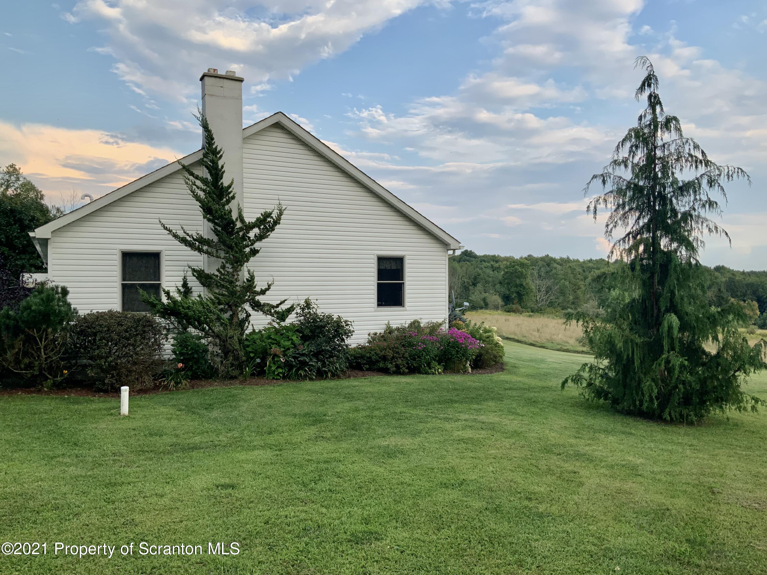 647 Bennett Road Meshoppen, PA 18630 - Photo 3 of 35 a front view of house with garden and trees