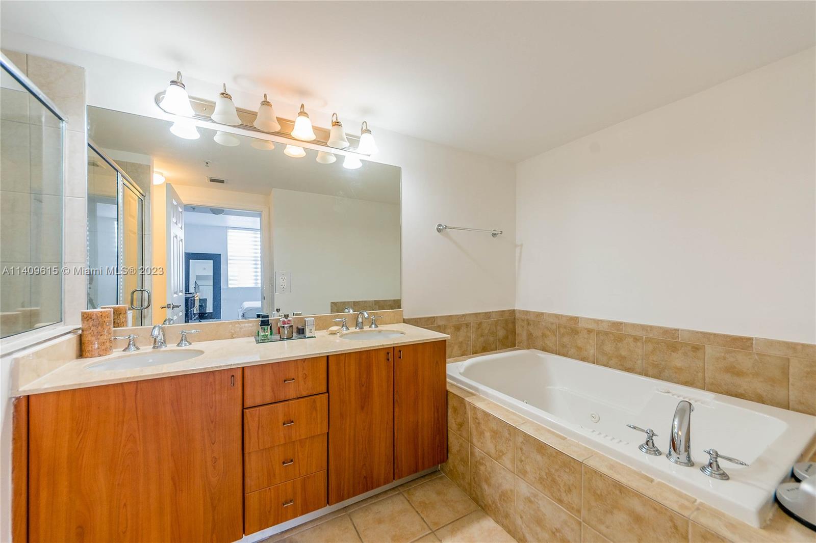 888 Douglas Road, Unit 1407 Coral Gables, FL 33134 - Photo 11 of 11 a bathroom with a tub a double vanity sink and mirror
