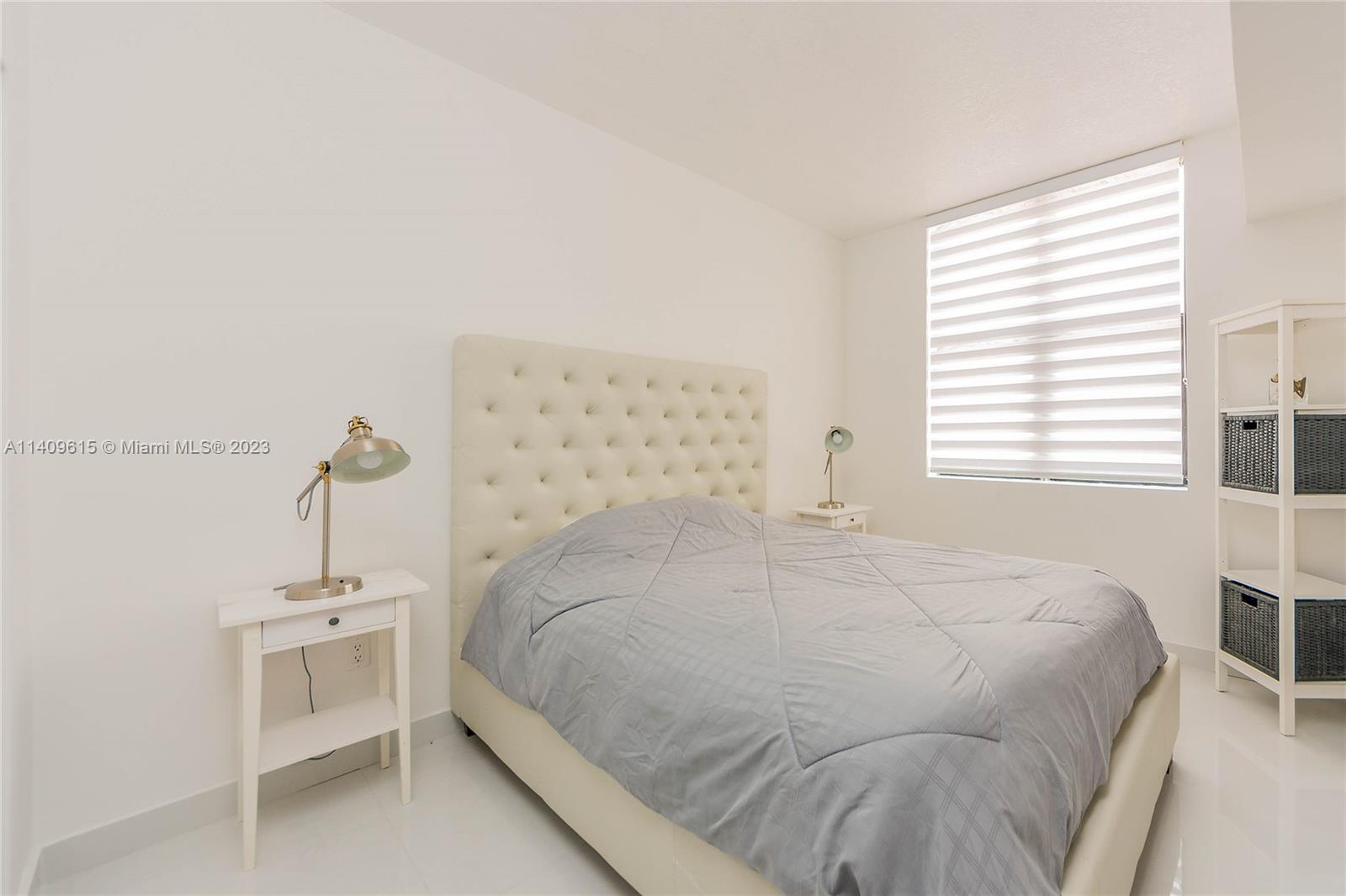 888 Douglas Road, Unit 1407 Coral Gables, FL 33134 - Photo 6 of 11 a bedroom with a bed and a window