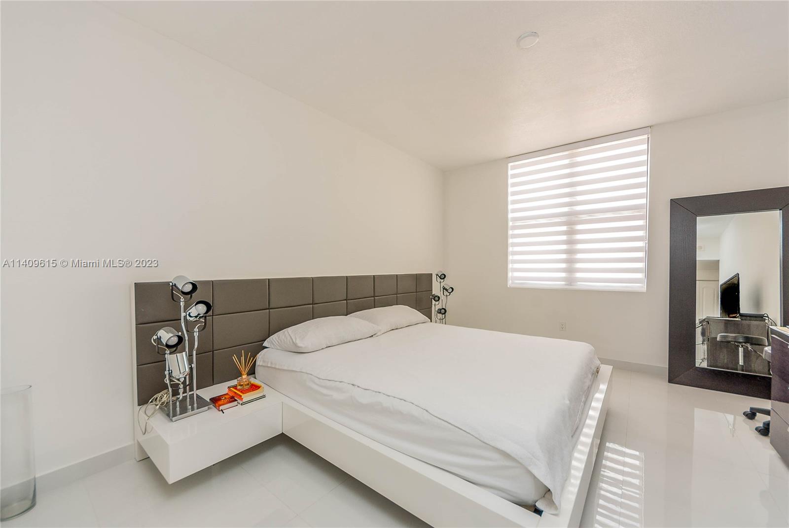 888 Douglas Road, Unit 1407 Coral Gables, FL 33134 - Photo 7 of 11 a bedroom with a bed a couch and a flat tv screen on a dresser