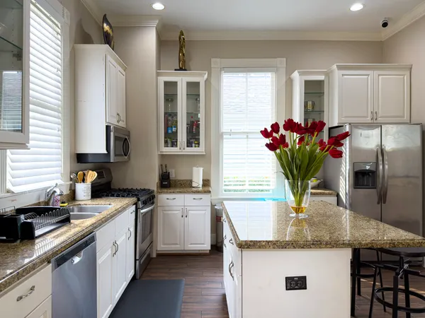 a kitchen with granite countertop a sink stainless steel appliances and cabinets