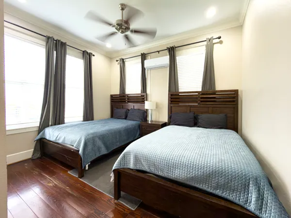 a bedroom with two beds and large windows