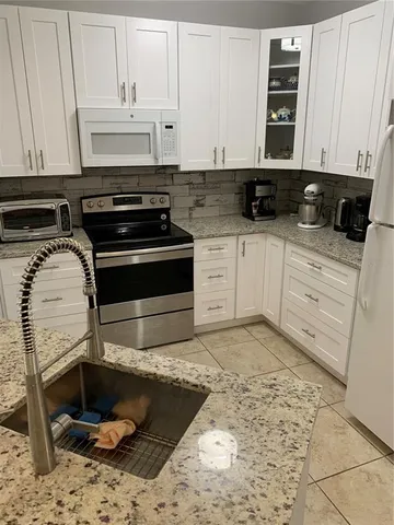 a kitchen with a stove and white cabinets