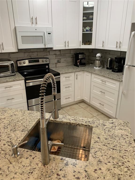5134 Northridge Road, Unit 112 Sarasota, FL 34238 - Photo 10 of 15 a kitchen with a stove and a refrigerator