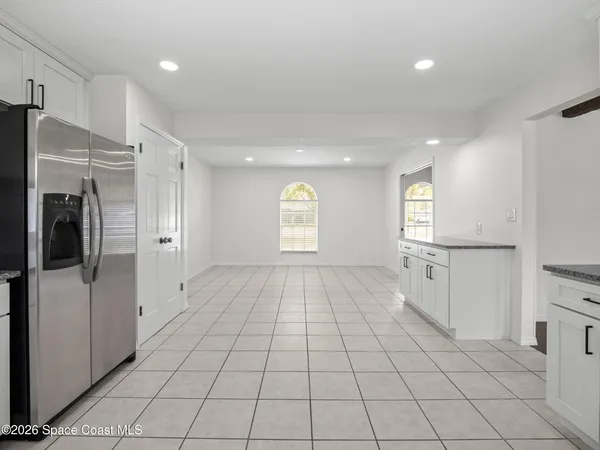 a large white kitchen with stainless steel appliances granite countertop a stove a sink and a white cabinets
