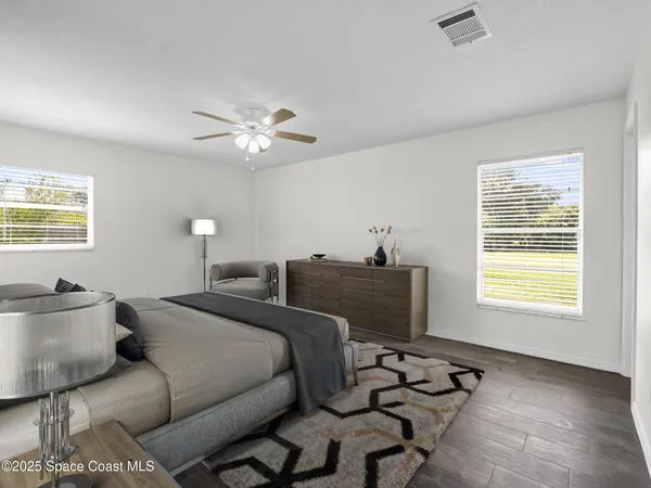 a spacious bathroom with a granite countertop sink toilet a large mirror a shower and a