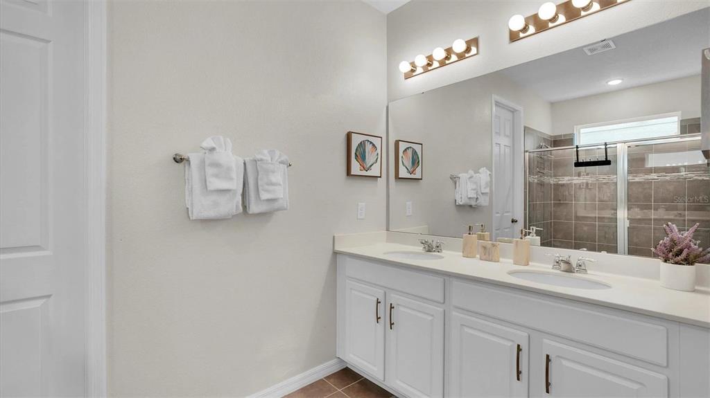 1840 Caribbean View Terrace Kissimmee, FL 34747 - Photo 14 of 56 a bathroom with a sink and a mirror