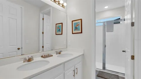 a bathroom with a sink mirror and painting on the wall
