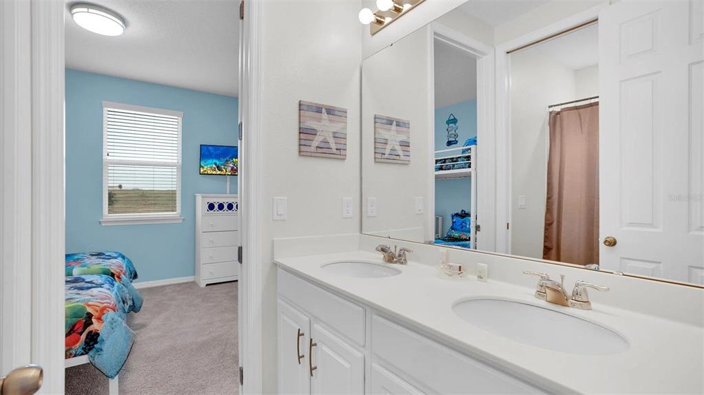 1840 Caribbean View Terrace Kissimmee, FL 34747 - Photo 28 of 56 a bathroom with a sink mirror and painting on the wall