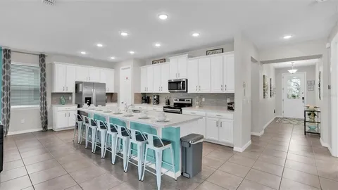 a kitchen with stainless steel appliances kitchen island granite countertop a refrigerator and a stove top oven