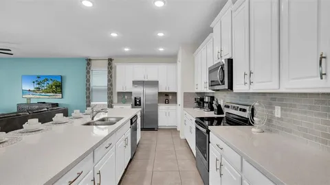 a kitchen with stainless steel appliances a sink stove refrigerator and cabinets