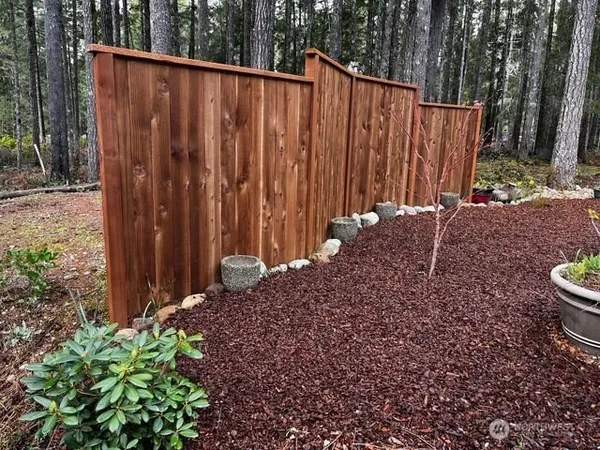 a view of a backyard with wooden fence