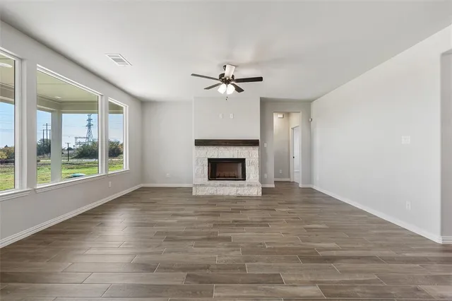 a view of an empty room with a fireplace and a window