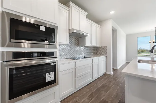 a kitchen with stainless steel appliances a stove microwave and cabinets