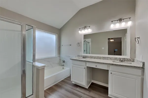 a spacious bathroom with a granite countertop sink mirror and bathtub