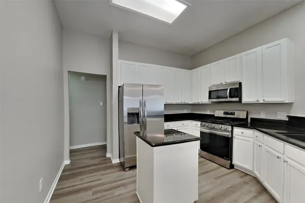 a kitchen with stainless steel appliances granite countertop a stove a sink and a refrigerator
