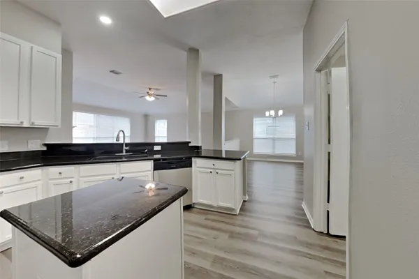 a kitchen with a refrigerator a sink and cabinets