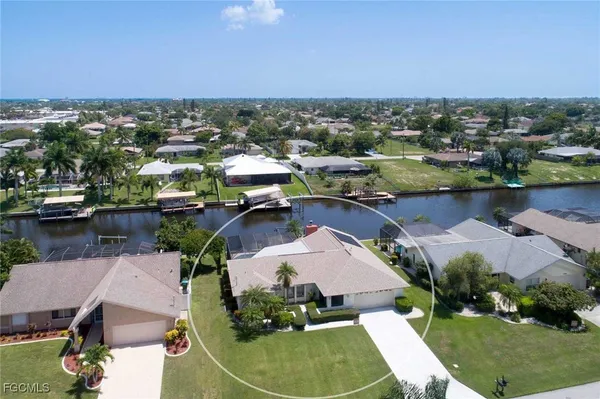 an aerial view of a house with a garden and lake view