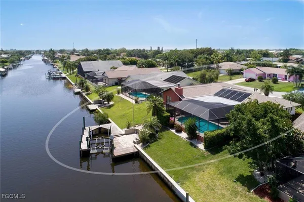 an aerial view of a house with a garden and lake view