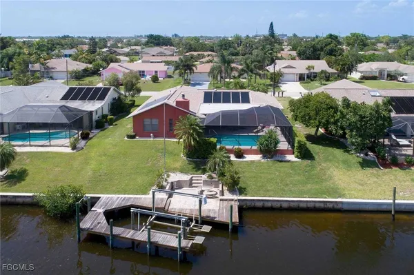 an aerial view of a house with swimming pool a yard and lake view