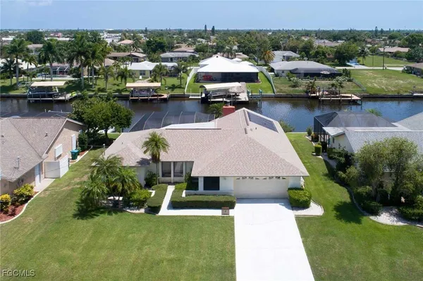an aerial view of a house with swimming pool and outdoor seating