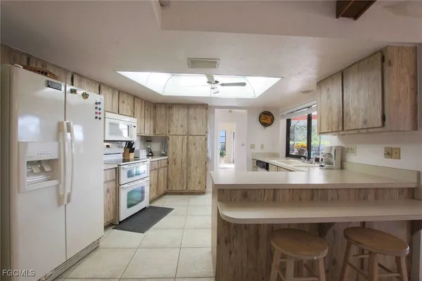a kitchen with kitchen island a sink stove and refrigerator