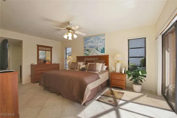 a spacious bedroom with a bed and a chandelier