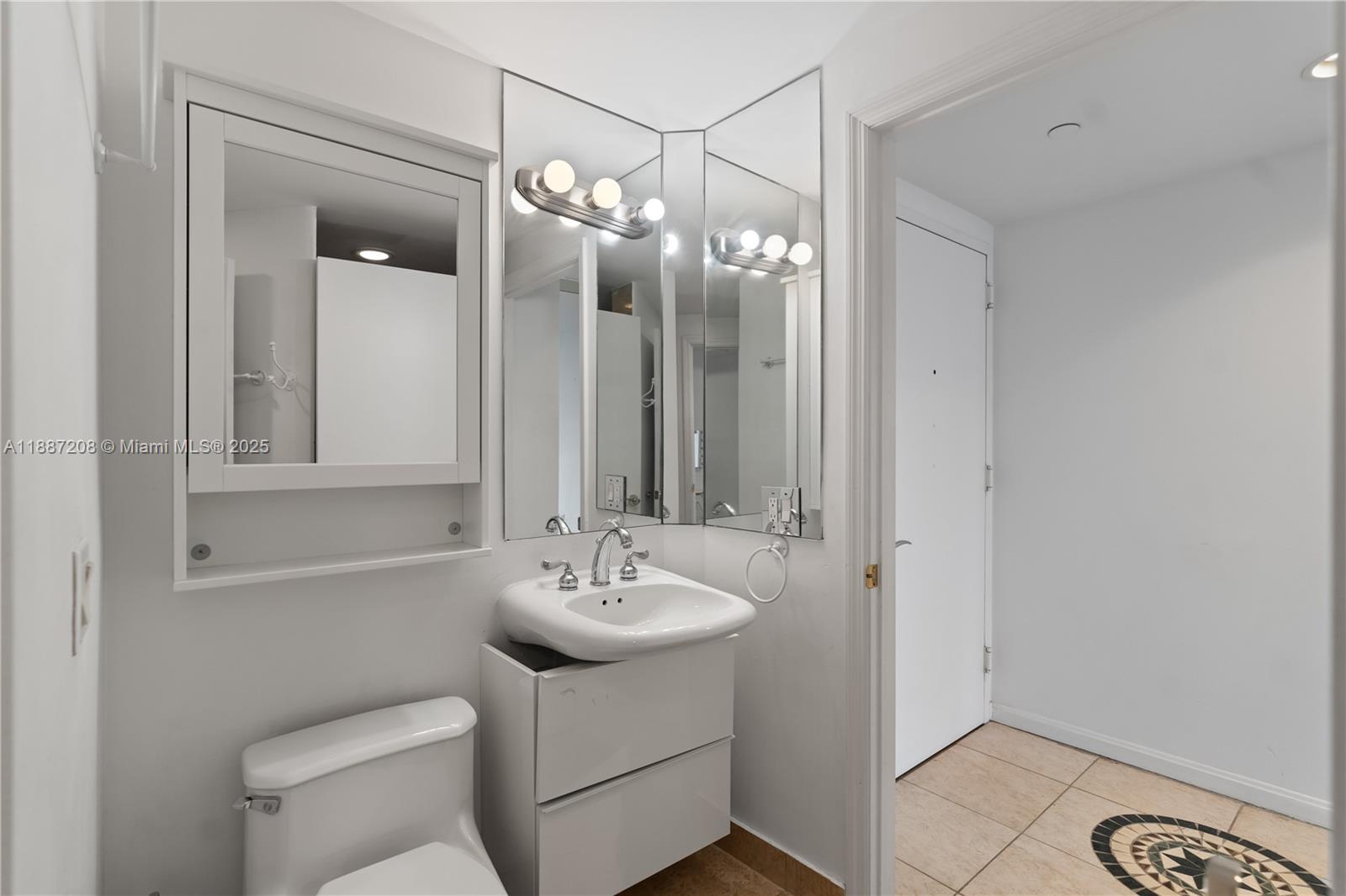 4779 Collins Avenue, Unit 506 Miami Beach, FL 33140 - Photo 26 of 53 a bathroom with a toilet sink and mirror