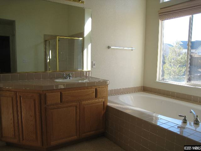 4522 Goodwin Road Sparks, NV 89436 - Photo 5 of 9 a bathroom with a granite countertop sink and a bathtub