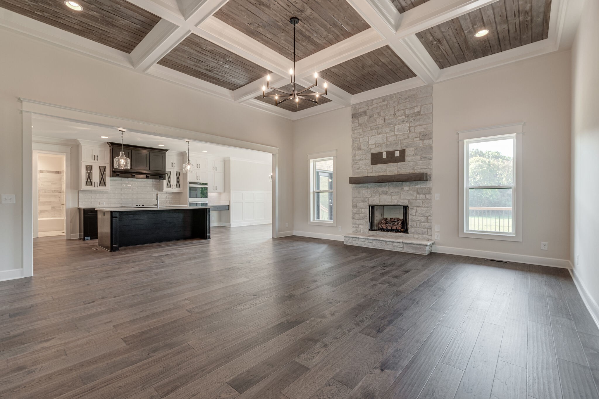 12599 North Milton Road Milton, TN 37118 - Photo 8 of 34 an empty room with wooden floor a kitchen view and a fireplace