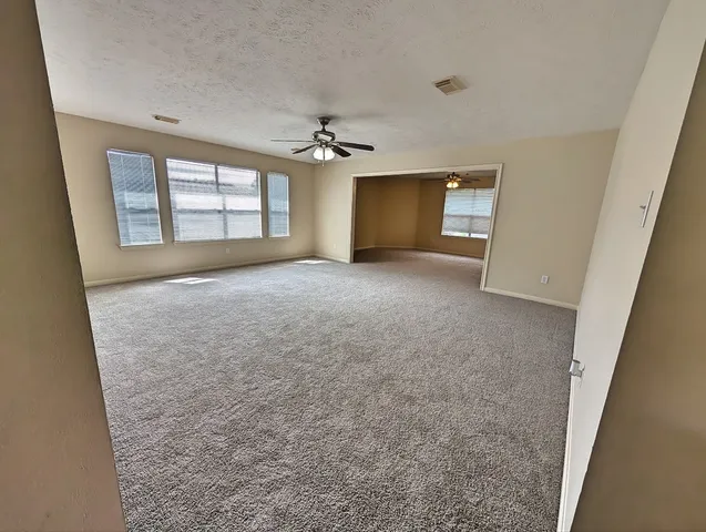an empty room with windows and cabinet