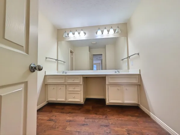 a spacious bathroom with a sink a large mirror and a vanity