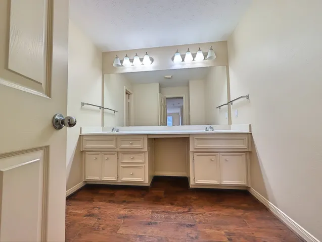 a spacious bathroom with a sink a large mirror and a vanity