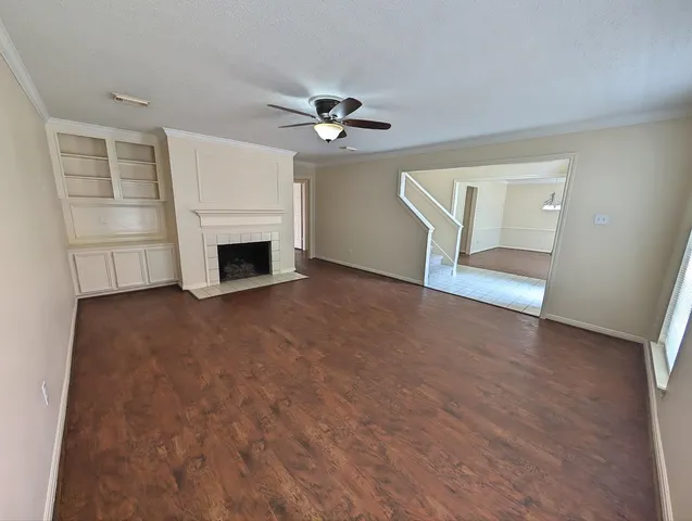 an empty room with windows and fireplace