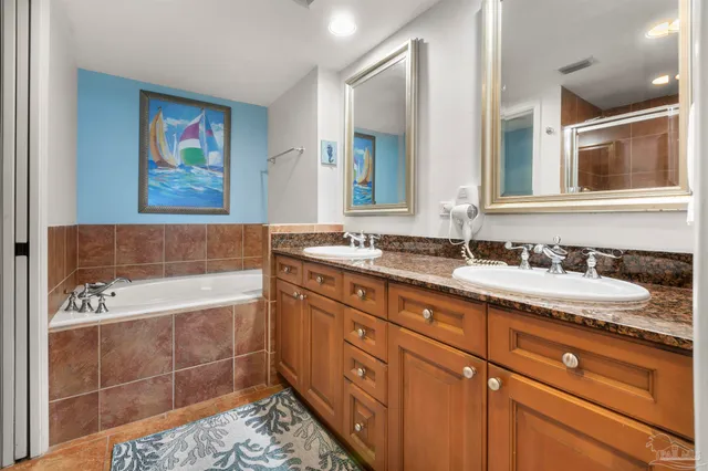 a bathroom with a granite countertop sink mirror and bathtub