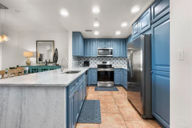 a kitchen with stainless steel appliances granite countertop a refrigerator a stove a sink and a oven