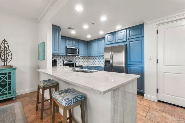 a kitchen with stainless steel appliances granite countertop a refrigerator a sink a stove a microwave oven and a refrigerator with wooden floor