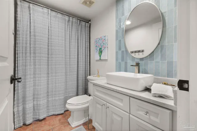 a bathroom with a toilet a sink and mirror