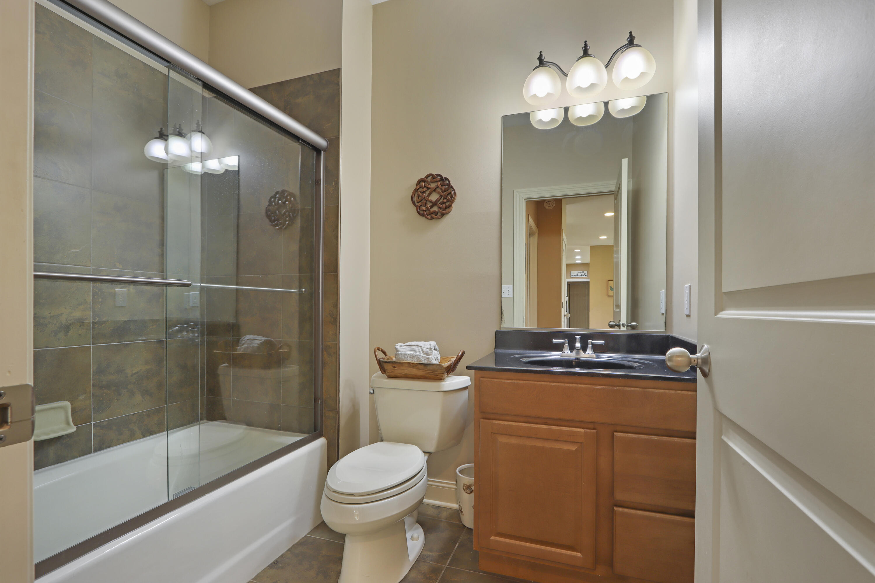 392 County Road B Fontana, WI 53125 - Photo 23 of 75 The ML Full Bathroom serves as a bathroom for the ML Bedroom as well as a guest bathroom and features a tile floor, single sink vanity and tub/shower with tile surround and glass shower door